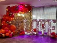 gold-sequin-wall-with-balloon-garland-and-floral-love