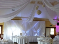 Grecian backdrop white uplighters and non swag front table
